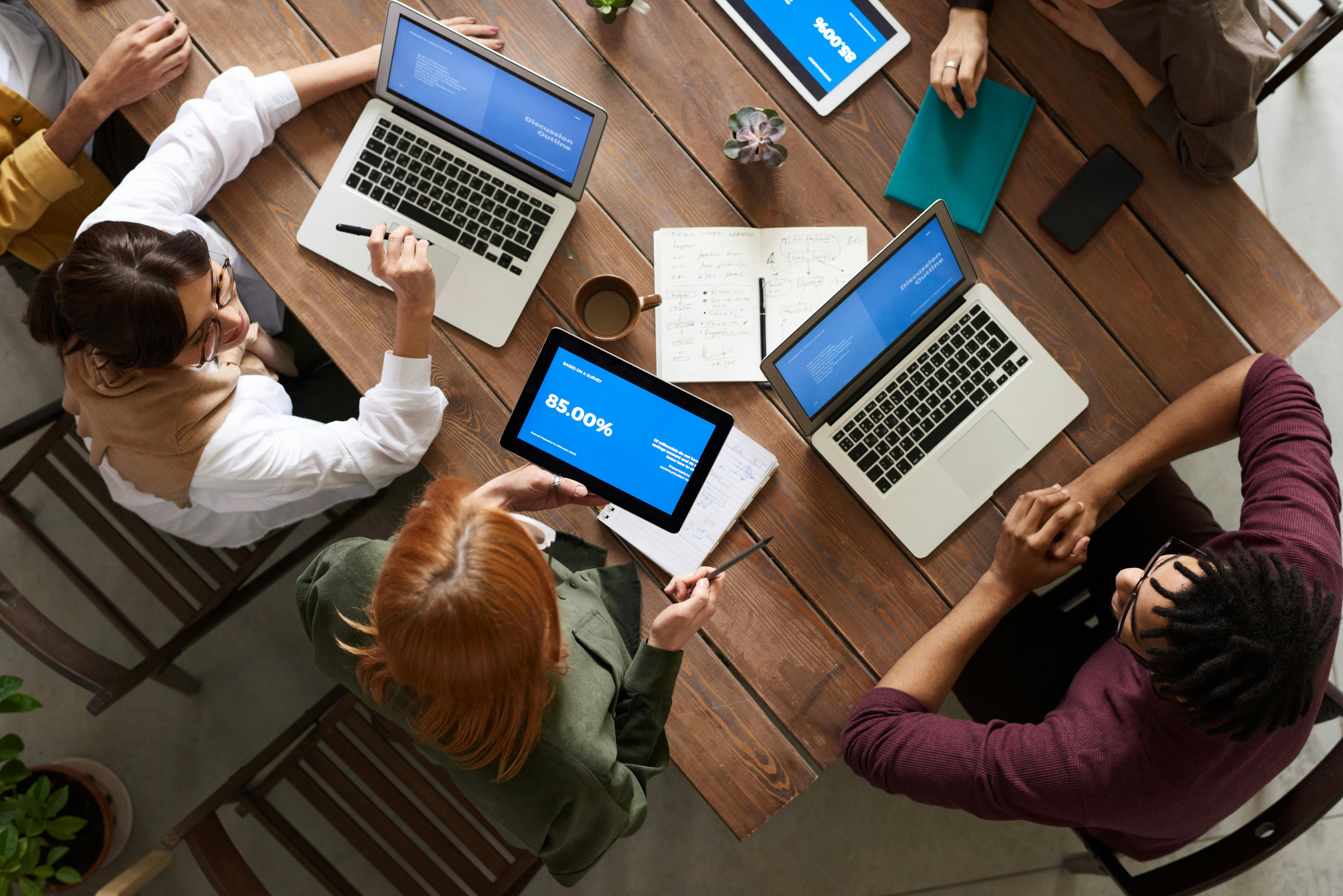 group of business people around a table with laptops