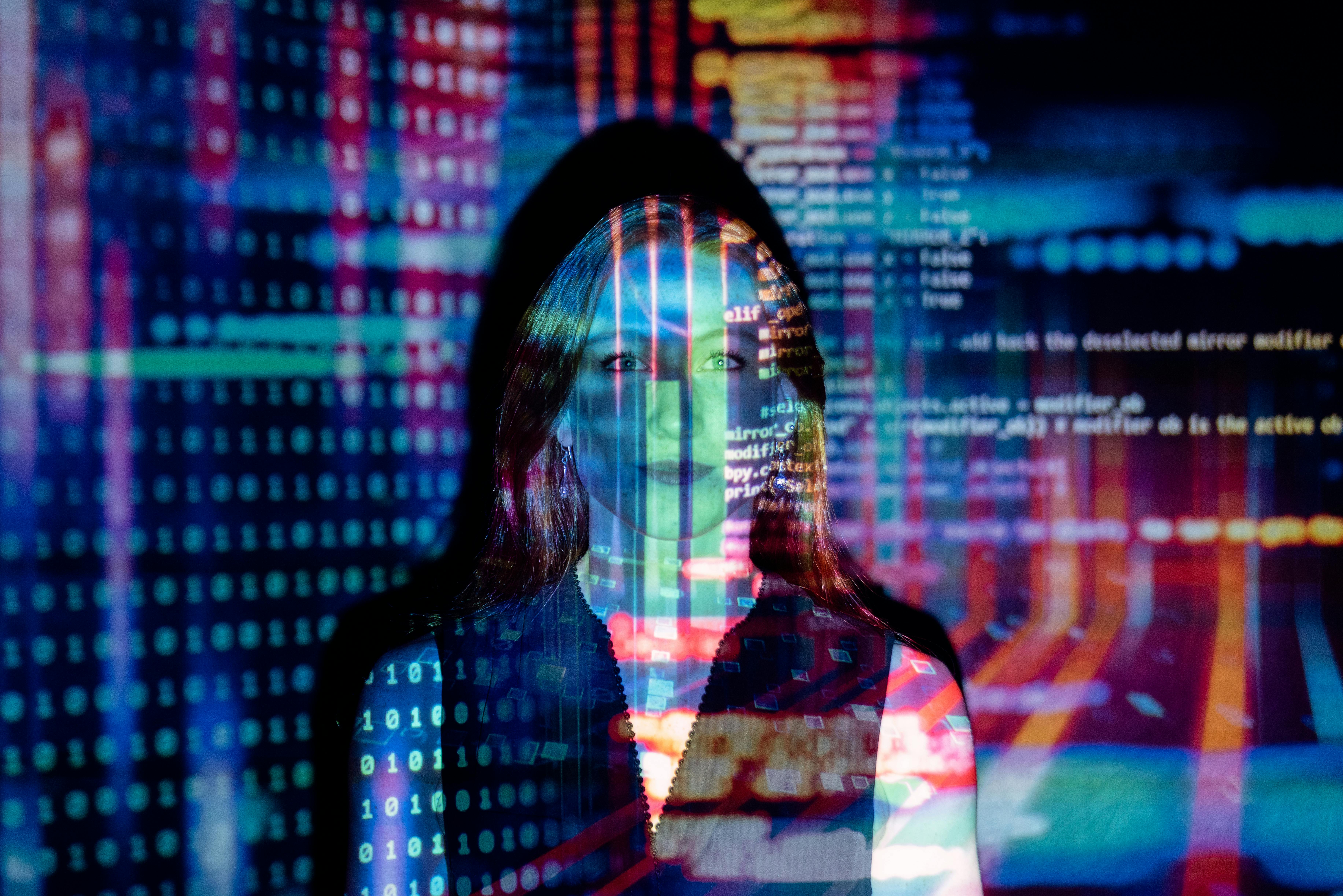 woman in front of projected screen showing code