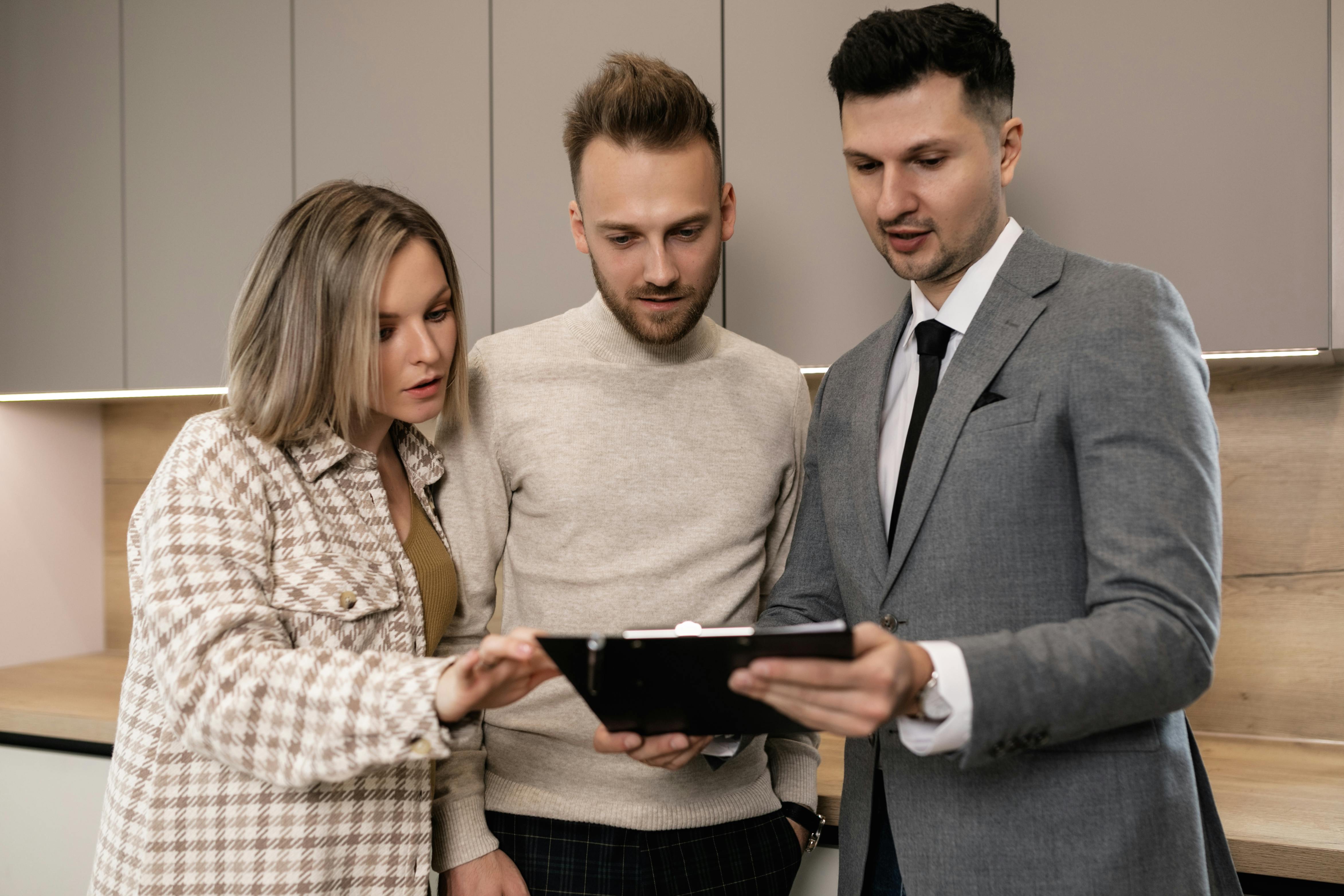 three employees looking at a proposal on a clipboard