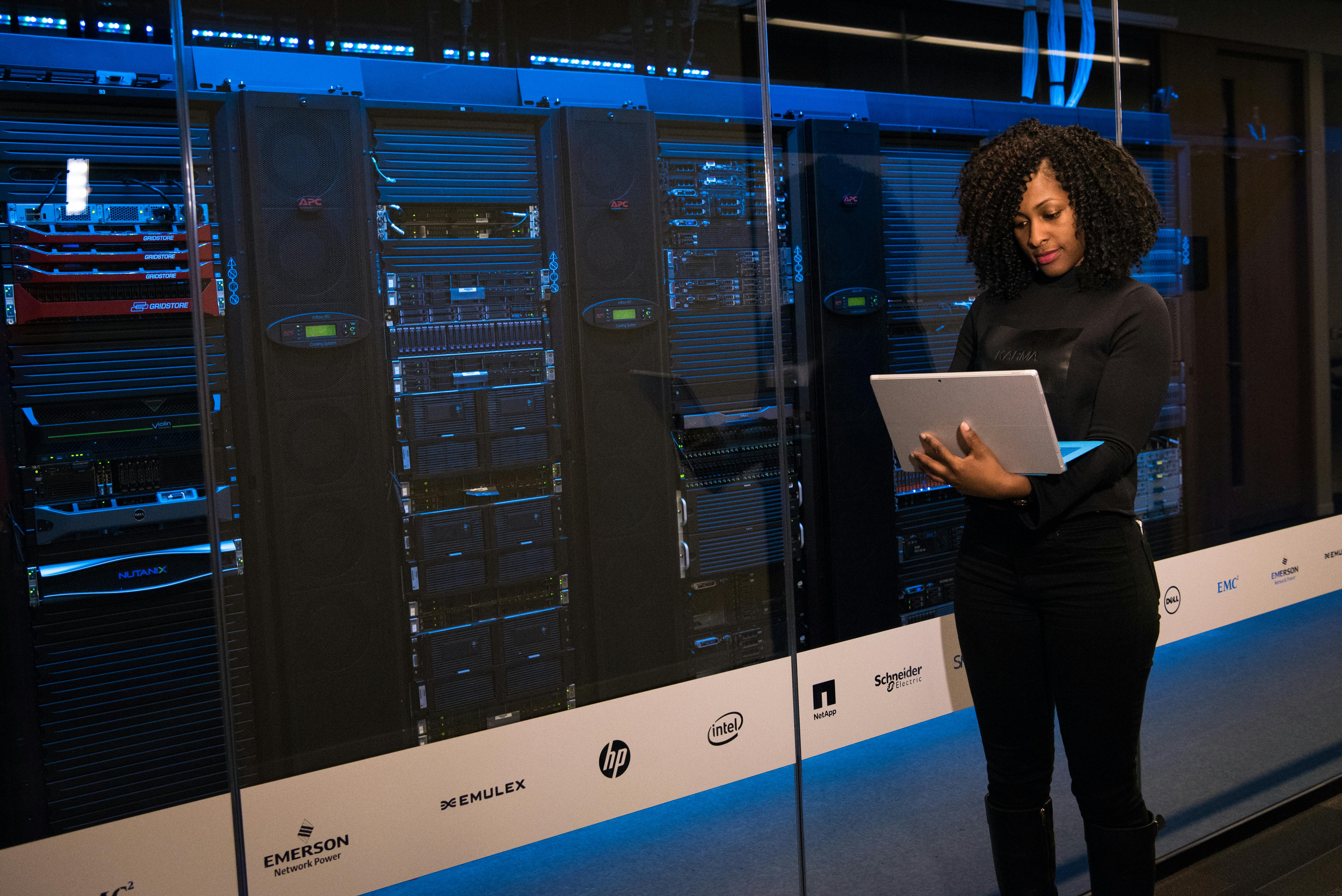 Woman with laptop in a server room