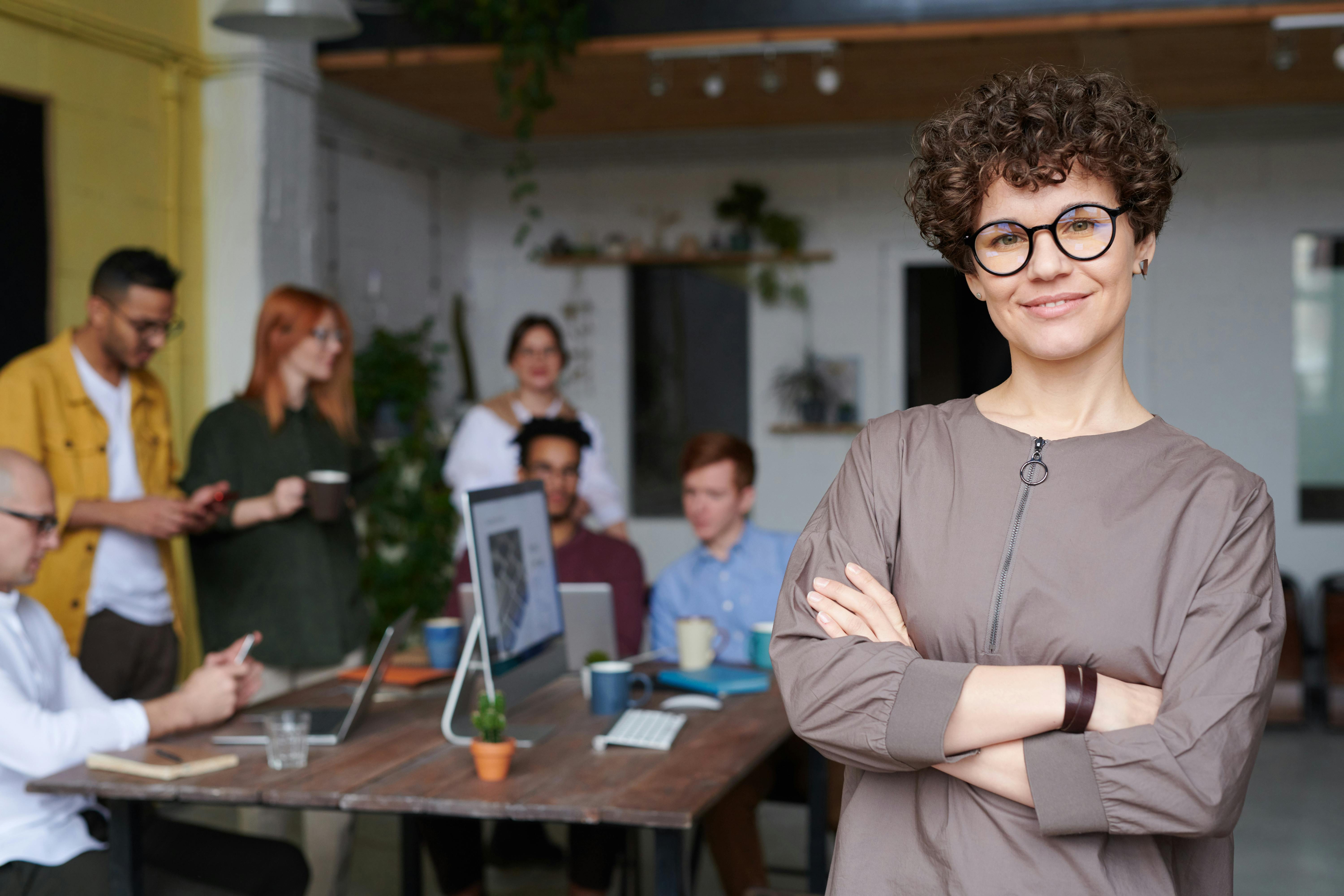 Group of business people, with woman in glasses in front of frame to right