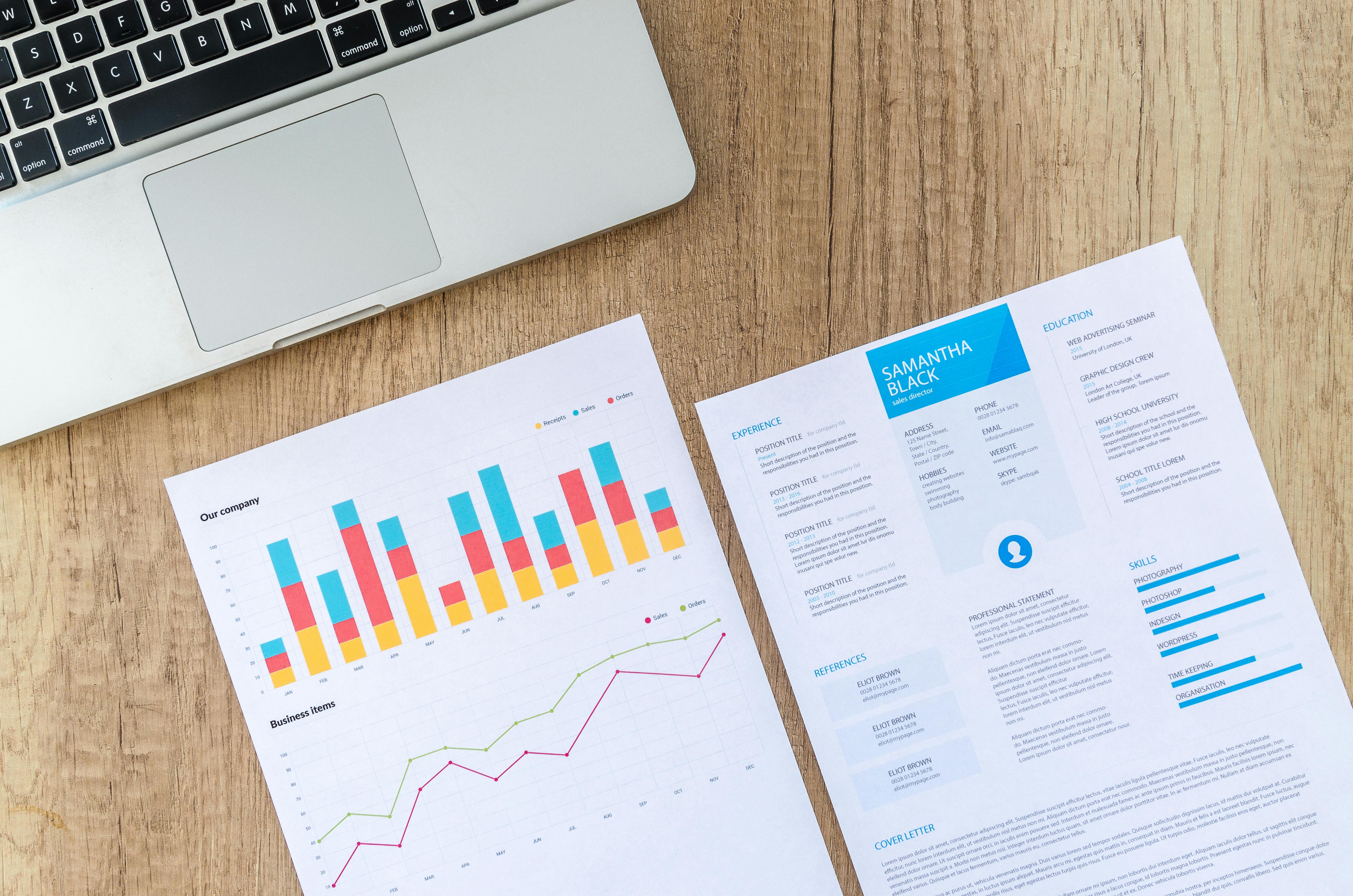 resume and company charts behind computer