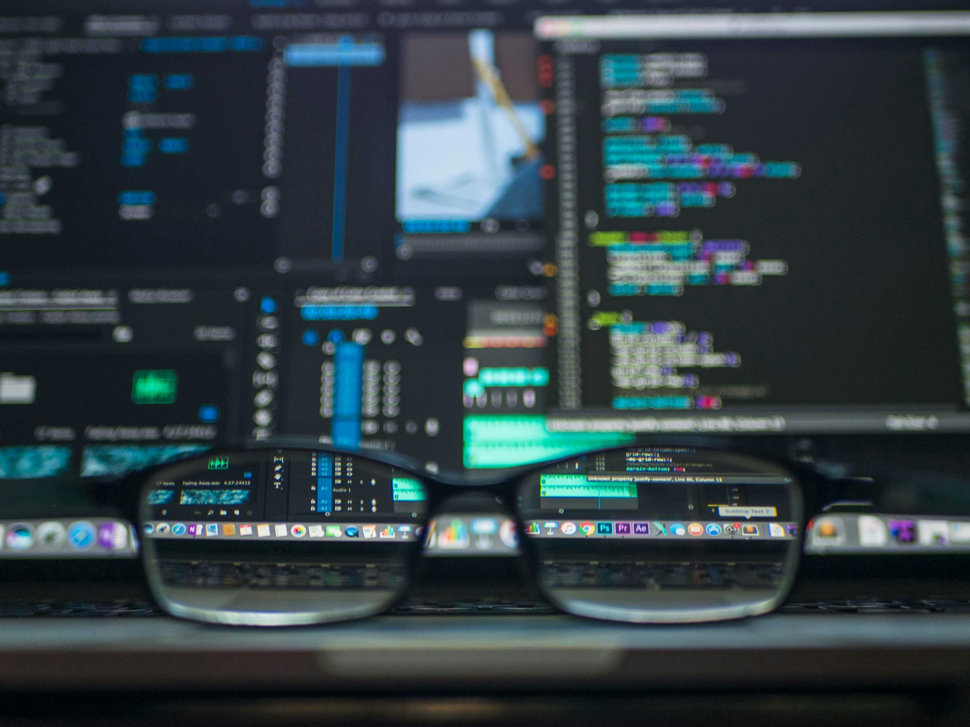 Glasses reflecting computer code and screens