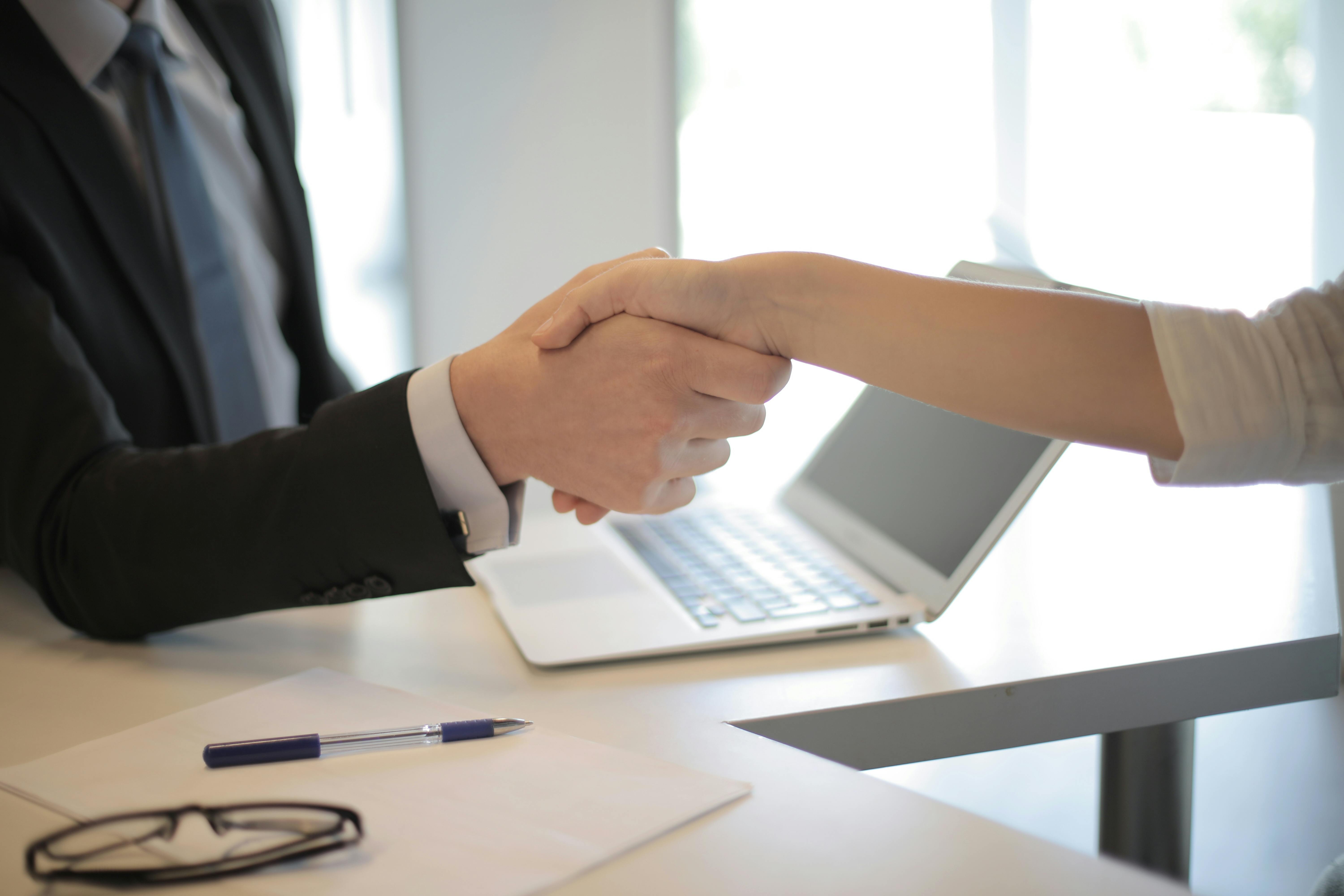 A woman and man shaking hands, zoomed in on hands
