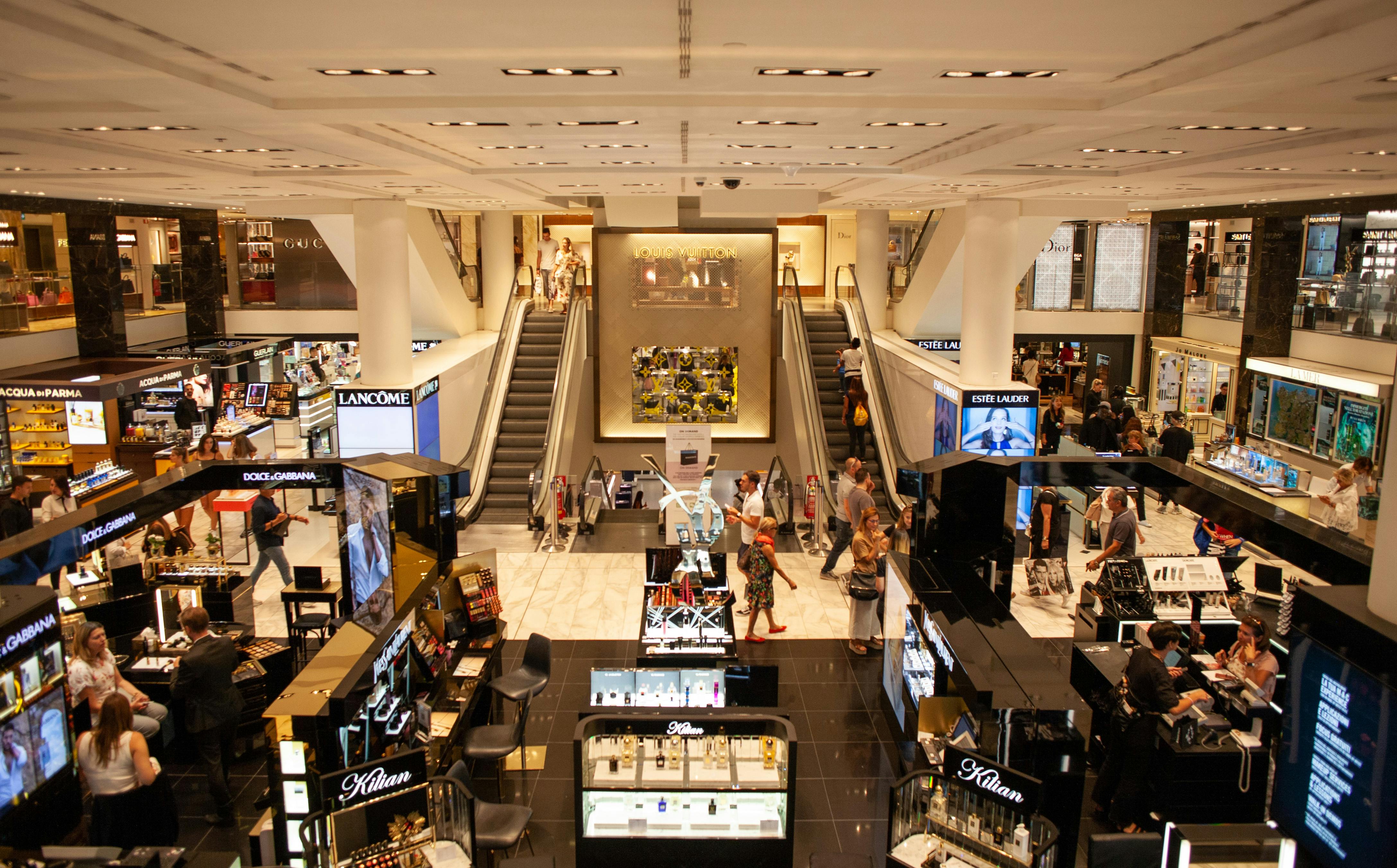 Busy shopping mall with luxury brands.