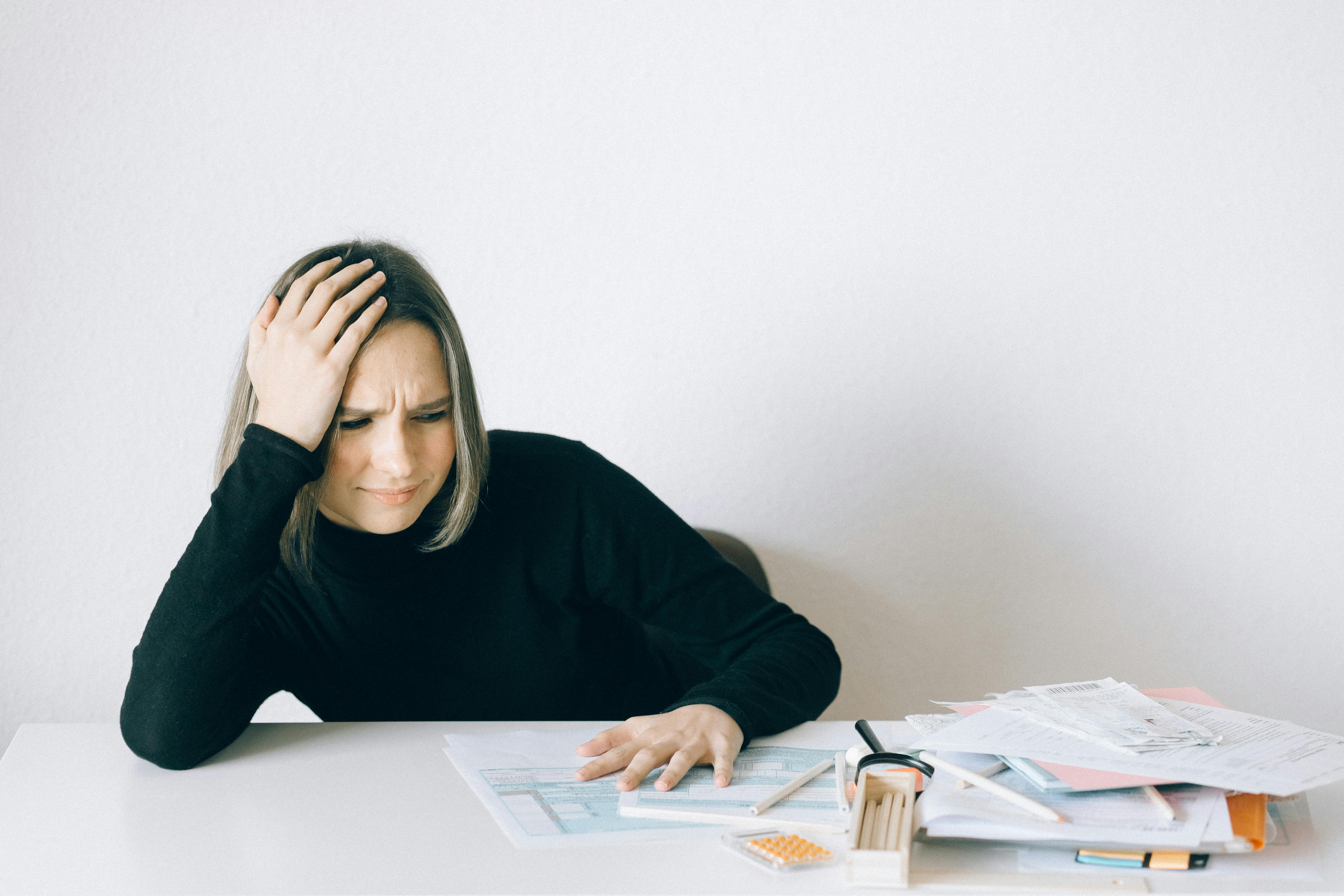 woman looking stressed looking at tax documents