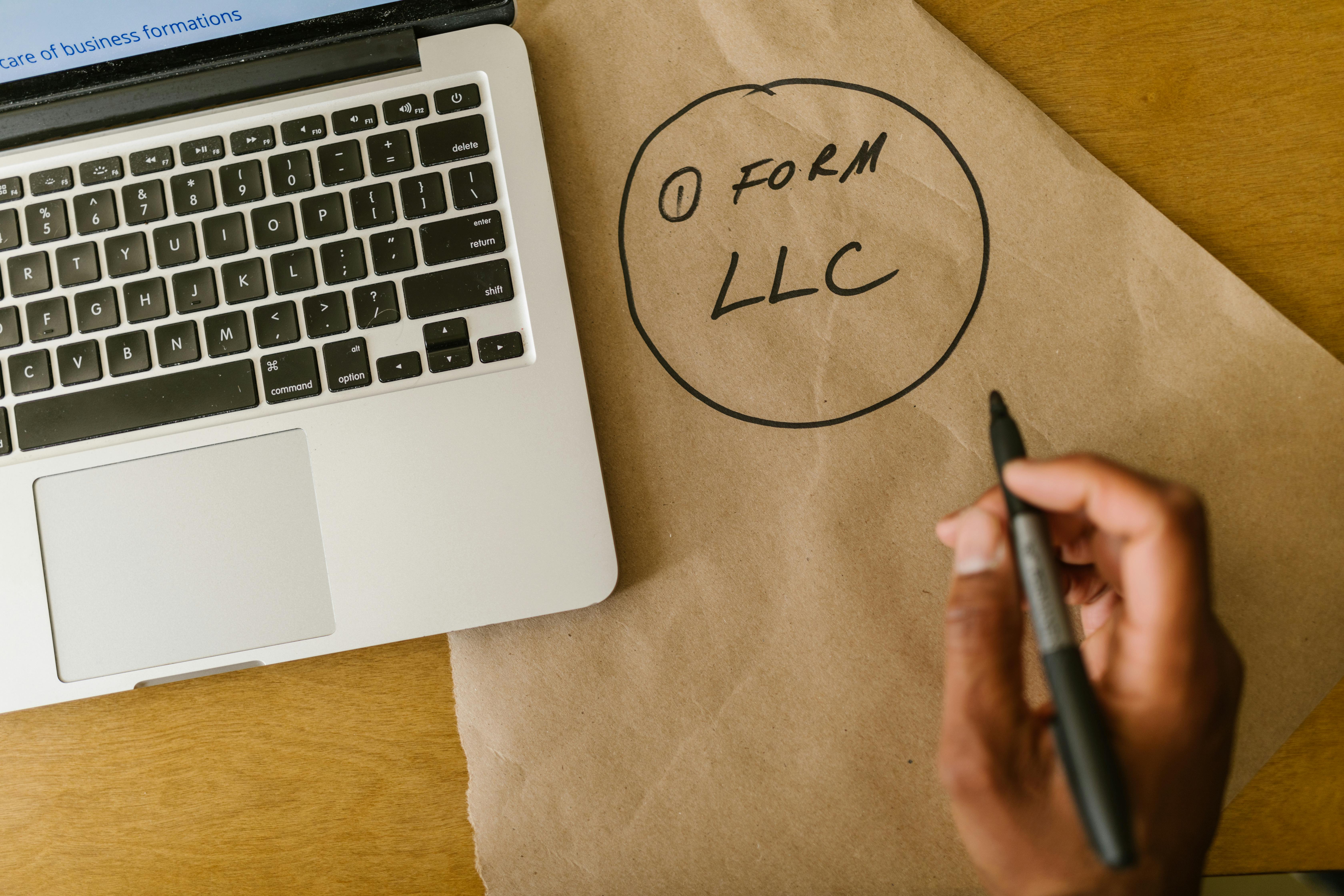 laptop and paper with form llc written on it