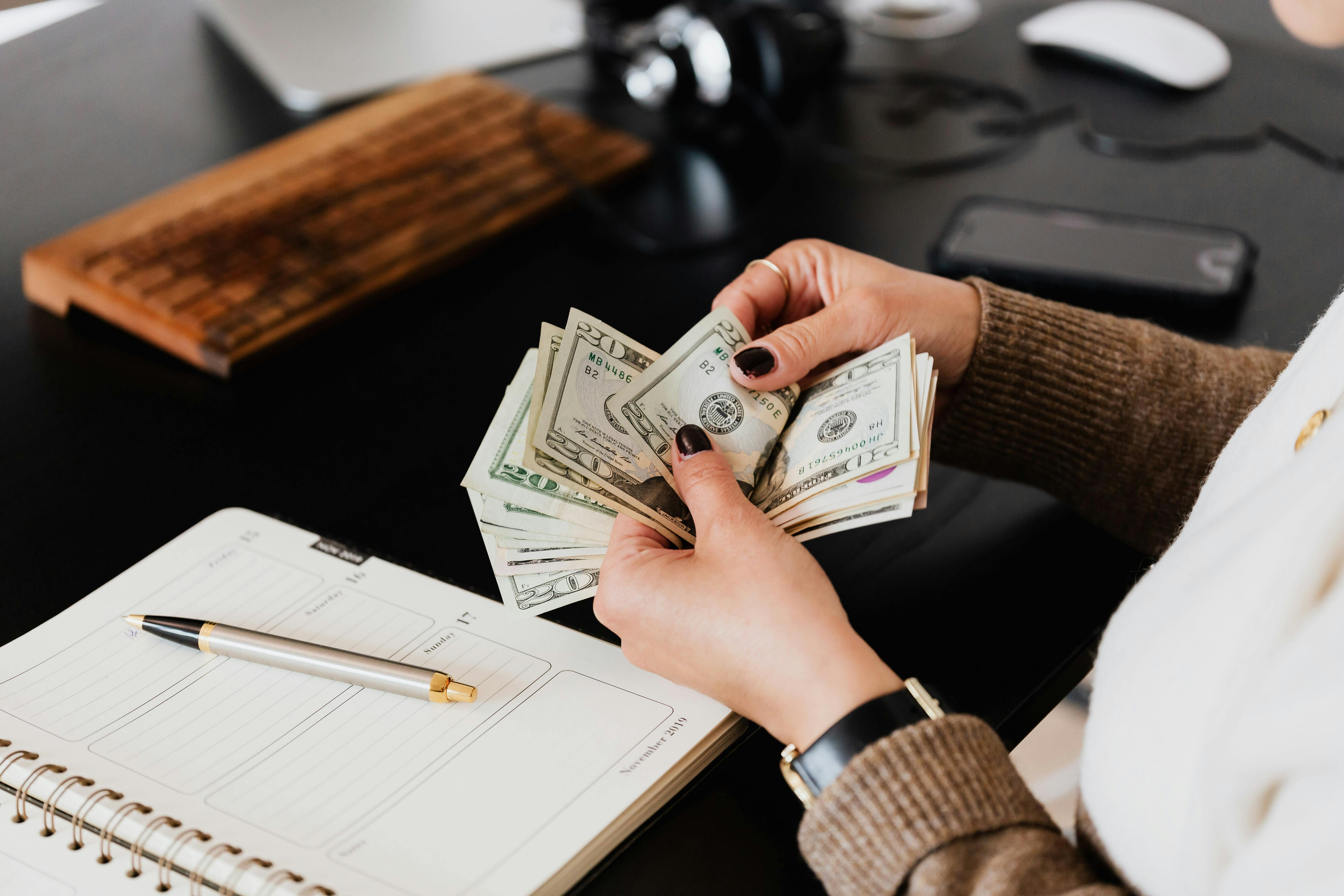 Money being counted by an employee sitting at a desk
